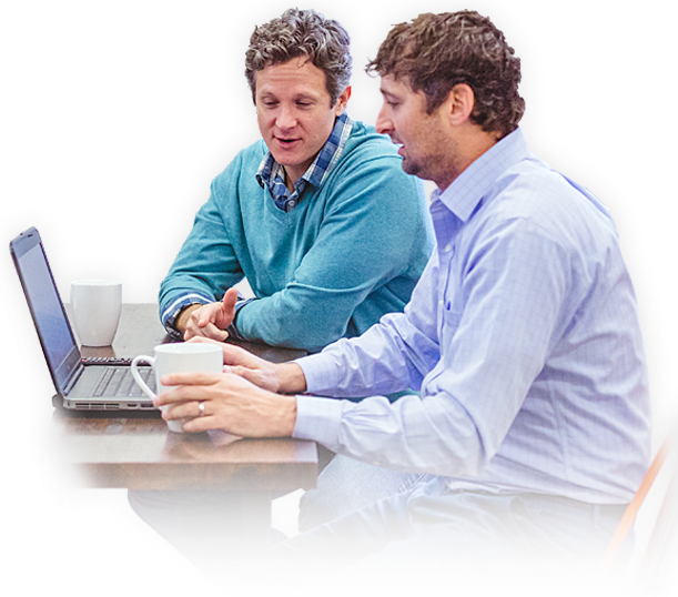 Two INETCO IT service providers collaborating in front of a laptop