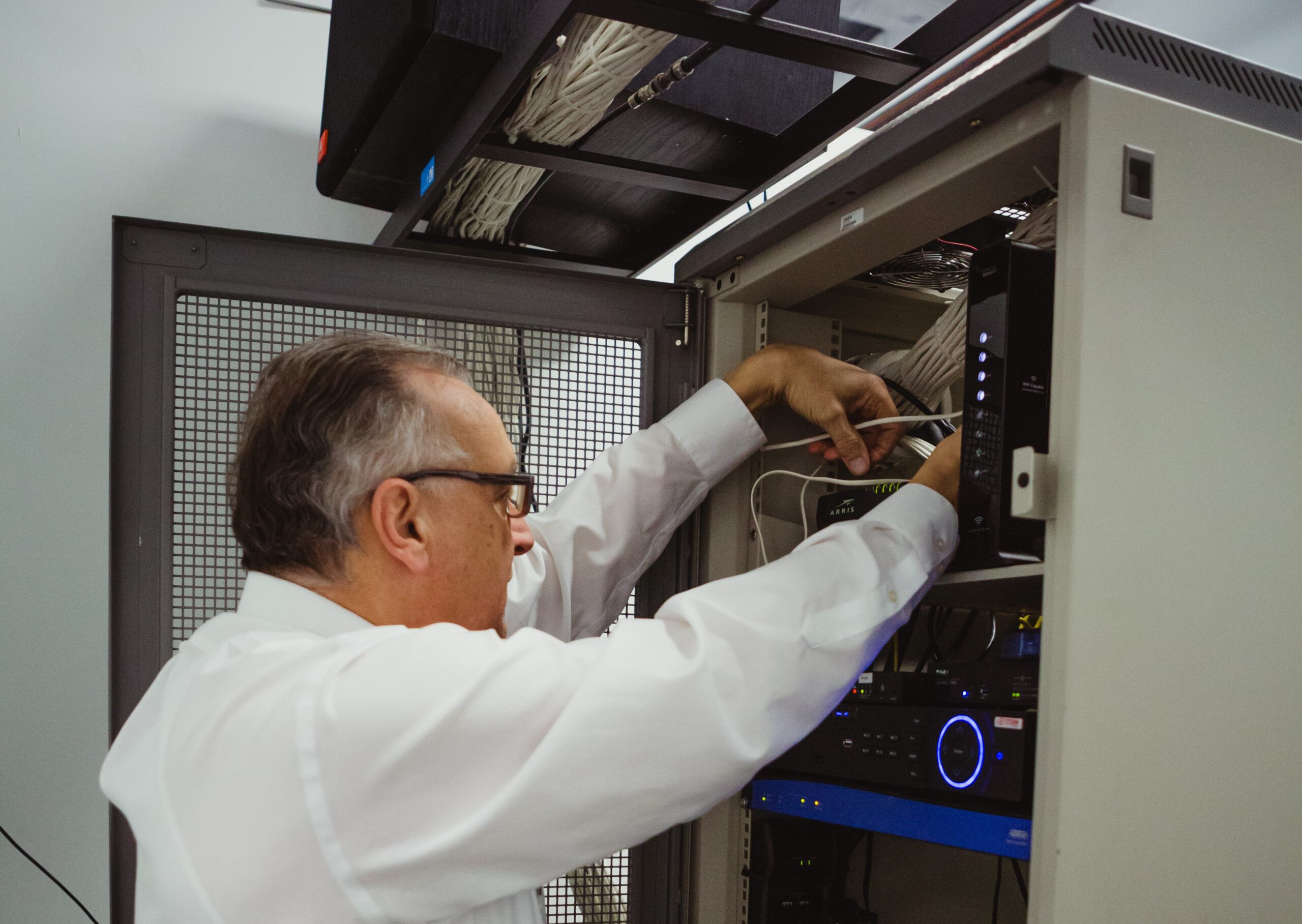 Technician maintaining a modern business server rack